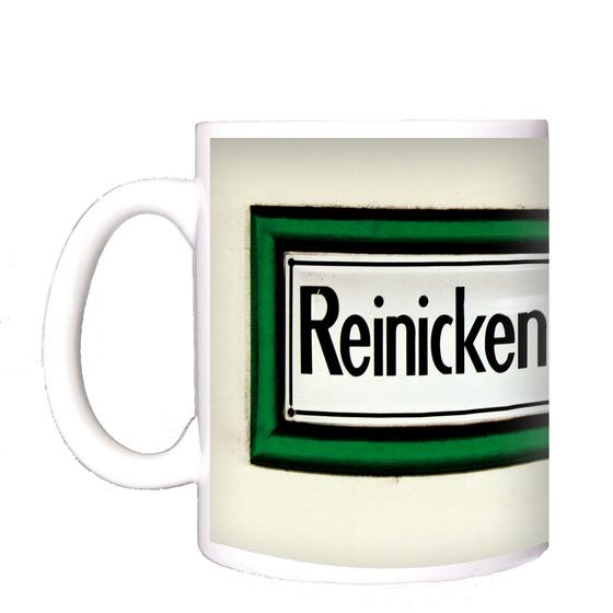 U-Bahnhof Reinickendorfer Straße Kaffeetasse - schwarze Schrift auf weißem Schild, mit dickem, grünem Rahmen, vor weißer Wand