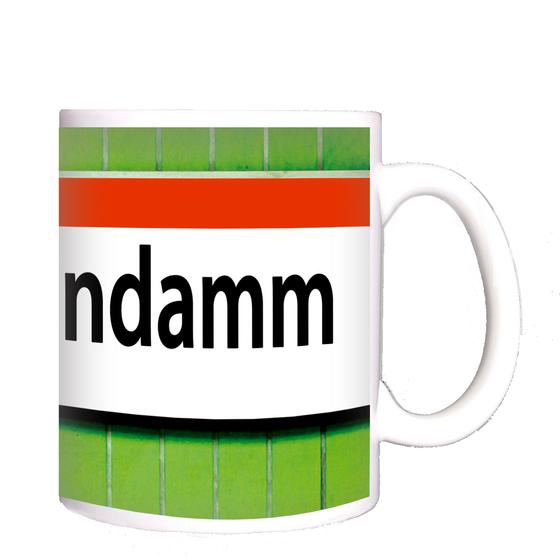 U-Bahnhof Kurfürstendamm Kaffeetasse - weißes Schild mit orangem Streifen und schwarzer Schrift auf grünem Fliesenhintergrund