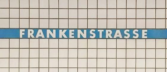 U-Bahn-Tasse Frankenstrasse der Nuernberger Linie U1 in der originalgetreuen Stations-Gestaltung - weiße Schrift auf blauem Streifen, Kachelhintergrund