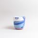 Handgefertigte Porzellan-Tasse von MK Studio mit Wellenstruktur, außen matt, innen glasiert, mit Farbverläufen aus eingefärbtem Porzellan.