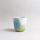 Handgefertigte Porzellan-Tasse von MK Studio mit Wellenstruktur, außen matt, innen glasiert, mit Farbverläufen aus eingefärbtem Porzellan.