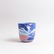 Handgefertigte Porzellan-Tasse von MK Studio mit Wellenstruktur, außen matt, innen glasiert, mit Farbverläufen aus eingefärbtem Porzellan.